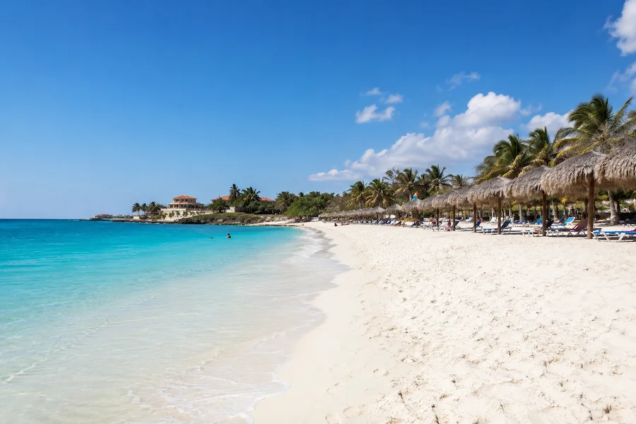 Playas del Este beach near Havana with turquoise water, white sand and palm-thatched umbrellas